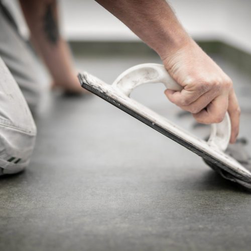 Fliesenleger bei der Arbeit, Renovierung eines Badezimmers Fliesenleger bei der Arbeit, Renovierung eines Badezimmers